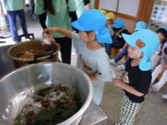 輪ゴムを巻いた布を鍋に入れます。