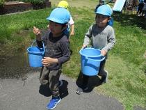 重たいバケツを運んでいる