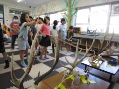 鹿の角めがけてロープを投げる子供たち