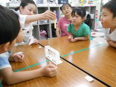 試験管を見せる講師とその周りで様子を見ている5人