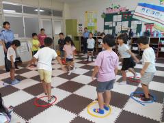 赤、黄、青のロープの輪の中に立ちゲームを楽しむ子供