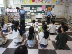 警察官2名が子どもたちの前に立ち話している