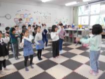 前に立っている子どもの真似をしてポーズをとる子どもたち