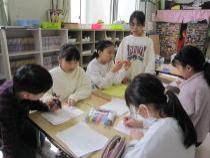 白い紙にマジックで文字を書く子どもたち