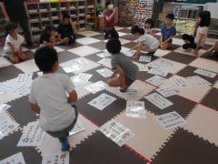 グループ対抗でお金かるたとりをしています