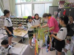 部屋で笹にかざりつけをしています