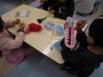 道具を使って編み物をしています