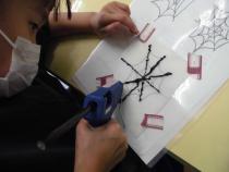 グルーガンでクモの巣を製作しています