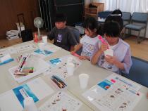 紙コップに絵を描いている