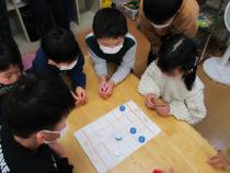 ペットボトルキャップで将棋をする子ども