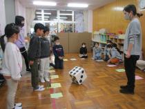 大きなサイコロを振るこども