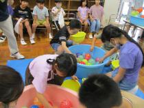 たらいに入ったヨーヨーを釣る子どもたち