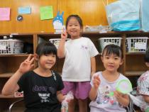 袋に入ったゴムボールを持ってブイサインする子供たち