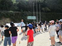 校庭で並んで話を聞く子供たち