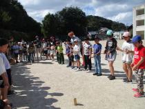 一本の棒を囲んでいるたくさんの人々