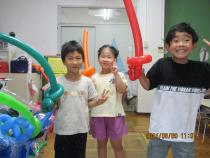 バルーンの剣を持ちポーズをとる子ども3人