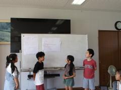 ホワイトボード前で説明する4人の子ども