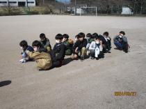 グラウンドで並んで座っている