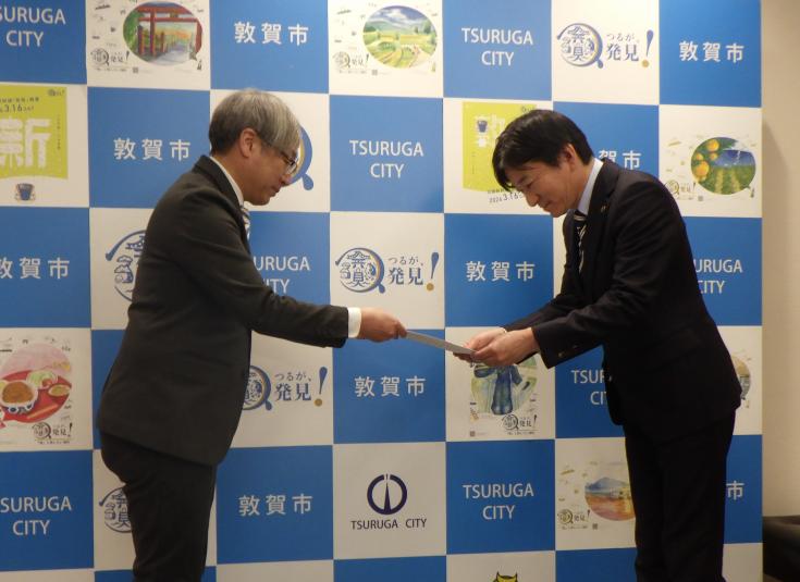 米澤市長に答申書を手渡す杉山委員長（左）